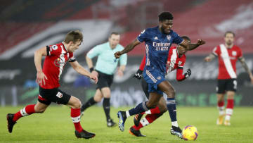 SOUTHAMPTON, ENGLAND - JANUARY 26: Thomas Partey of Arsenal runs with the ball away from James Ward-Prowse (L) and Ibrahima Diallo (obscure/R) of Southampton during the Premier League match between Southampton and Arsenal at St Mary's Stadium on January 26, 2021 in Southampton, England. Sporting stadiums around the UK remain under strict restrictions due to the Coronavirus Pandemic as Government social distancing laws prohibit fans inside venues resulting in games being played behind closed doors. (Photo by Frank Augstein - Pool/Getty Images)