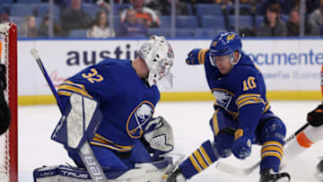 Jan 22, 2022; Buffalo, New York, USA; Buffalo Sabres defenseman Henri Jokiharju (10) tries to stop as goaltender Michael Houser (32) makes a save during the first period against the Philadelphia Flyers at KeyBank Center. Mandatory Credit: Timothy T. Ludwig-USA TODAY Sports