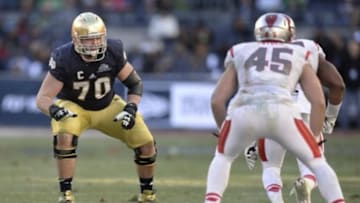Dec 28, 2013; Bronx, NY, USA; Notre Dame Fighting Irish offensive tackle Zack Martin (70) blocks against the Rutgers Scarlet Knights during the second half of the Pinstripe Bowl at Yankees Stadium. Notre Dame Fighting Irish won the game 29-16. Mandatory Credit: Joe Camporeale-USA TODAY Sports