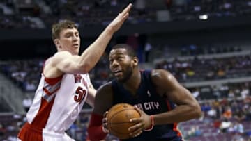 Apr 13, 2014; Auburn Hills, MI, USA; Detroit Pistons forward Greg Monroe (10) dribbles around Toronto Raptors forward Tyler Hansbrough (50) in the fourth quarter at The Palace of Auburn Hills. Mandatory Credit: Rick Osentoski-USA TODAY Sports