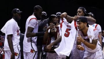 Mar 31, 2013; Indianapolis, IN, USA; Louisville Cardinals players including Russ Smith (middle) and Peyton Siva (right) celebrate with the midwest regional championship trophy and the jersey of injured teammate Kevin Ware (not pictured) after the finals of the Midwest regional of the 2013 NCAA tournament against the Duke Blue Devils at Lucas Oil Stadium. Louisville won 85-63. Mandatory Credit: Brian Spurlock-USA TODAY Sports