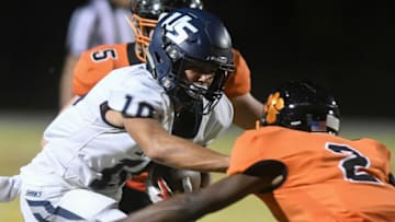 Brandon Inniss of University is brought down by Chavis Thompson (2) and Brock Holland (5) of Cocoa during Friday's Class 4A state semifinal.High School Football University At Cocoa