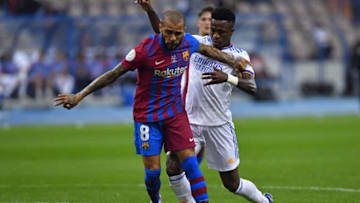 Real Madrid's Brazilian forward Vinicius Junior marks Barcelona's Brazilian defender Dani Alves. (Photo by -/AFP via Getty Images)