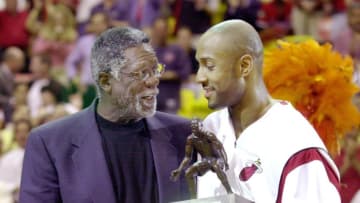 Alonzo Mourning of the Miami Heat (R) smiles as he receives the trophy from basketball legend Bill Russell (L) after Mourning was named Defensive Player of the Year by the NBA(Photo by RHONA WISE/AFP via Getty Images)