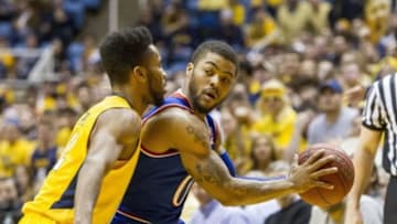 Jan 12, 2016; Morgantown, WV, USA; Kansas Jayhawks guard Frank Mason III (0) is pressured by West Virginia Mountaineers guard Tarik Phillip (12) during the first half at the WVU Coliseum. Mandatory Credit: Ben Queen-USA TODAY Sports