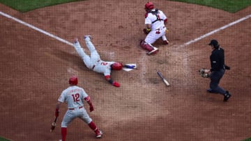 Oct 7, 2022; St. Louis, Missouri, USA; Philadelphia Phillies second baseman Jean Segura (2) slides safely past St. Louis Cardinals catcher Yadier Molina (4) in the ninth inning during game one of the Wild Card series for the 2022 MLB Playoffs at Busch Stadium. Mandatory Credit: Jeff Curry-USA TODAY Sports