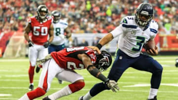 Nov 10, 2013; Atlanta, GA, USA; Seattle Seahawks quarterback Russell Wilson (3) stiff arms Atlanta Falcons safety Thomas DeCoud (28) on a run in the first half at the Georgia Dome. Mandatory Credit: Daniel Shirey-USA TODAY Sports