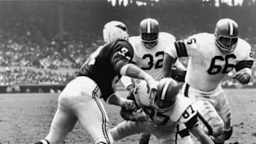 American football player Jim Brown, running back for the Cleveland Browns, runs the ball behind three blockers in action against the St. Louis Cardinals during a home game at Cleveland Municipal Stadium, Cleveland, Ohio, 1960s. (Photo by Robert Riger/Getty Images)