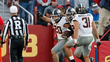 AMES, IA - OCTOBER 26: Safety Malcolm Rodriguez #20 of the Oklahoma State Cowboys celebrates with teammates defensive end Tyler Lacy #89, and safety Kolby Harvell-Peel #31 of the Oklahoma State Cowboys after intercepting a pass and scoring a touchdown in the second half of play at Jack Trice Stadium on October 26, 2019 in Ames, Iowa. The Oklahoma State Cowboys won 34-27 over the Iowa State Cyclones.(Photo by David Purdy/Getty Images)