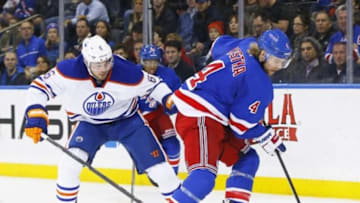 Nov 9, 2014; New York, NY, USA; New York Rangers defenseman Michael Kostka (4) plays the puck as Edmonton Oilers left wing Jesse Joensuu (6) defends during the third period at Madison Square Garden. The Oilers defeated the Rangers 3-1. Mandatory Credit: Andy Marlin-USA TODAY Sports