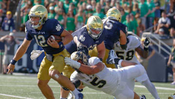 SOUTH BEND, IN - SEPTEMBER 18: Tyler Buchner #12 of the Notre Dame Fighting Irish runs the ball as George Karlaftis #5 of the Purdue Boilermakers tries to make the tackle at Notre Dame Stadium on September 18, 2021 in South Bend, Indiana. (Photo by Michael Hickey/Getty Images)