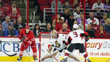 Nov 7, 2015; Raleigh, NC, USA; Carolina Hurricanes forward Jeff Skinner (53) holds onto the puck behind the Ottawa Senators goalie Andrew Hammond (30) during the 3rd period at PNC Arena. The Carolina Hurricanes defeated the Ottawa Senators 3-2 in overtime. Mandatory Credit: James Guillory-USA TODAY Sports