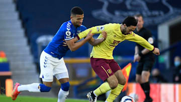 LIVERPOOL, ENGLAND - MARCH 13: Dwight McNeil of Burnley is challenged by Mason Holgate of Everton during the Premier League match between Everton and Burnley at Goodison Park on March 13, 2021 in Liverpool, England. Sporting stadiums around the UK remain under strict restrictions due to the Coronavirus Pandemic as Government social distancing laws prohibit fans inside venues resulting in games being played behind closed doors. (Photo by Peter Powell - Pool/Getty Images)