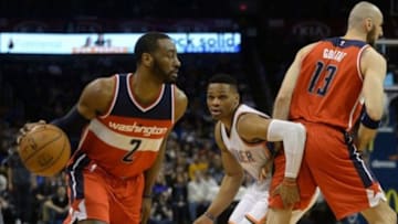 Feb 1, 2016; Oklahoma City, OK, USA; Washington Wizards guard John Wall (2) dribbles the ball around Oklahoma City Thunder guard Russell Westbrook (0) and Wizards center Marcin Gortat (13) during the first quarter at Chesapeake Energy Arena. Mandatory Credit: Mark D. Smith-USA TODAY Sports