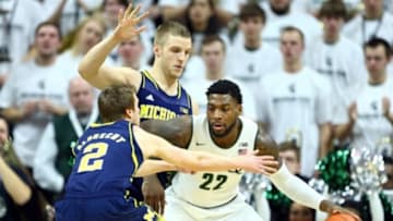 Feb 1, 2015; East Lansing, MI, USA; Michigan State Spartans guard/forward Branden Dawson (22) dribbles the ball between Michigan Wolverines guard Spike Albrecht (2) and Michigan Wolverines forward Max Bielfeldt (44) during the first half at Jack Breslin Student Events Center. Mandatory Credit: Mike Carter-USA TODAY Sports