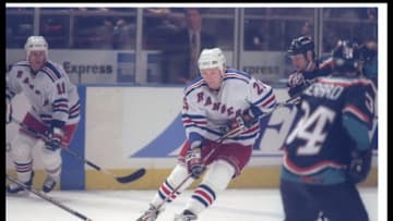 11 Dec 1996: Defenseman Alexander Karpovstev of the New York Rangers (center) moves the puck during a game against the New York Islanders at Madison Square Garden in New York City, New York. The Islanders won the game, 5-3.