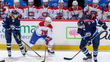 WINNIPEG, MB - MARCH 30: Tyler Myers #57 of the Winnipeg Jets plays the puck away from Artturi Lehkonen #62 of the Montreal Canadiens during third period action at the Bell MTS Place on March 30, 2019 in Winnipeg, Manitoba, Canada. The Habs defeated the Jets 3-1. (Photo by Jonathan Kozub/NHLI via Getty Images)