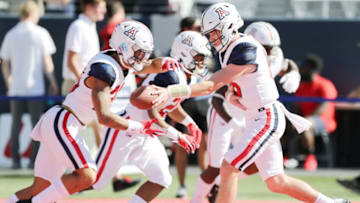 TUCSON, ARIZONA - NOVEMBER 13: Quarterback Will Plummer #15 of the Arizona Wildcats hands off the ball while warming up before the first half of the NCAAF game against Utah Utes at Arizona Stadium on November 13, 2021 in Tucson, Arizona. (Photo by Rebecca Noble/Getty Images)