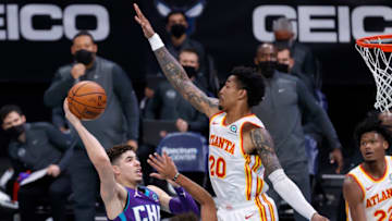 CHARLOTTE, NORTH CAROLINA - JANUARY 09: LaMelo Ball #2 of the Charlotte Hornets attempts a shot against John Collins #20 of the Atlanta Hawks during the third quarter of their game at Spectrum Center on January 09, 2021 in Charlotte, North Carolina. NOTE TO USER: User expressly acknowledges and agrees that, by downloading and or using this photograph, User is consenting to the terms and conditions of the Getty Images License Agreement. (Photo by Jared C. Tilton/Getty Images)