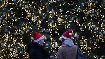 BERLIN, GERMANY - DECEMBER 22: Two women wearing Santa Claus hats chat in front of the annual Christmas tree at the Brandenburg Gate during the second wave of the coronavirus pandemic on December 22, 2020 in Berlin, Germany. Germany is going into a Christmas like no other as a hard lockdown remains in place and authorities struggle to bring down stubbornly-high daily rates of Covid-19 infections and deaths. (Photo by Sean Gallup/Getty Images)