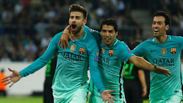 TOPSHOT - Barcelona's defender Gerard Pique (L) celebrates scoring the 1-2 goal with his teammates Uruguayan forward Luis Suarez and midfielder Sergio Busquets during the UEFA Champions League first-leg group C football match between Borussia Moenchengladbach and FC Barcelona at the Borussia Park in Moenchengladbach, western Germany on September 28, 2016. / AFP / Odd ANDERSEN (Photo credit should read ODD ANDERSEN/AFP/Getty Images)
