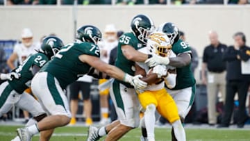 EAST LANSING, MI - SEPTEMBER 14: Joe Bachie #35 and Raequan Williams #99 of the Michigan State Spartans tackle Eno Benjamin #3 of the Arizona State Sun Devils in the second half of the game at Spartan Stadium on September 14, 2019 in East Lansing, Michigan. Arizona State defeated Michigan State 10-7. (Photo by Joe Robbins/Getty Images)