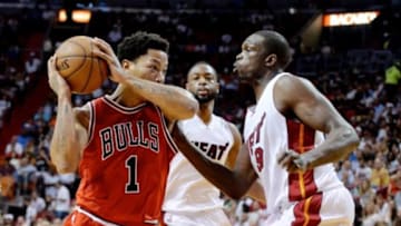 Apr 9, 2015; Miami, FL, USA; Chicago Bulls guard Derrick Rose (1) is defended by Miami Heat forward Luol Deng (9) during the first half at American Airlines Arena. Mandatory Credit: Steve Mitchell-USA TODAY Sports