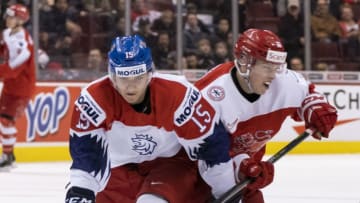 VANCOUVER, BC - DECEMBER 31: Jakub Lauko #15 of the Czech Republic and David Madsen #23 of Denmark battle for the loose puck in Group A hockey action of the 2019 IIHF World Junior Championship on December, 31, 2018 at Rogers Arena in Vancouver, British Columbia, Canada. (Photo by Rich Lam/Getty Images)