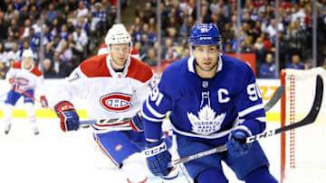 John Tavares #91 of the Toronto Maple Leafs and Brett Kulak #17 of the Montreal Canadiens chase the puck. (Photo by Vaughn Ridley/Getty Images)