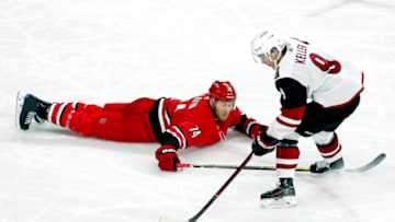 The Carolina Hurricanes' Jaccob Slavin (74) hits the ice as he defends the Arizona Coyotes' Clayton Keller (9) during the third period at PNC Arena in Raleigh, N.C., on Thursday, March 22, 2018. The Canes won, 6-5. (Chris Seward/Raleigh News & Observer/TNS via Getty Images)
