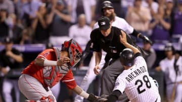 DENVER, CO - MAY 08: Nolan Arenado #28 of the Colorado Rockies scores at the plate in the seventh inning against catcher Martin Maldonado #12 of the Los Angeles Angels of Anaheim at Coors Field on May 8, 2018 in Denver, Colorado. (Photo by Matthew Stockman/Getty Images)