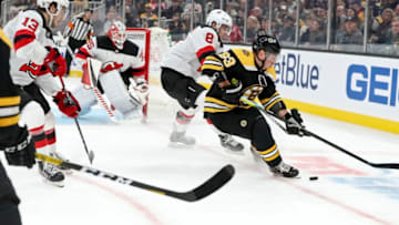 BOSTON - OCTOBER 12: Boston Bruins center Brad Marchand (63) controls the puck with pressure from New Jersey Devils defenseman Will Butcher (8) during the second period. The Boston Bruins host the New Jersey Devils in their home opener regular season NHL hockey game at TD Garden in Boston on Oct. 12, 2019. (Photo by Matthew J. Lee/The Boston Globe via Getty Images)