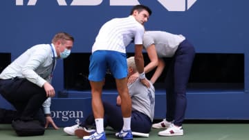 NEW YORK, NEW YORK - SEPTEMBER 06: Novak Djokovic of Serbia tends to a lineswoman after inadvertently striking her with a ball hit in frustration during his Men's Singles fourth round match against Pablo Carreno Busta of Spain on Day Seven of the 2020 US Open at the USTA Billie Jean King National Tennis Center on September 6, 2020 in the Queens borough of New York City. (Photo by Al Bello/Getty Images)