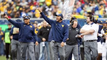 Nov 28, 2015; Morgantown, WV, USA; West Virginia Mountaineers assistant coach Lonnie Galloway (center) calls in a play during the second quarter against the Iowa State Cyclones at Milan Puskar Stadium. Mandatory Credit: Ben Queen-USA TODAY Sports