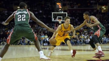 Oct 14, 2014; Cleveland, OH, USA; Cleveland Cavaliers guard Matthew Dellavedova (8) drives between Milwaukee Bucks forward Khris Middleton (22) and guard Giannis Antetokounmpo (34) in the second quarter at Quicken Loans Arena. Mandatory Credit: David Richard-USA TODAY Sports