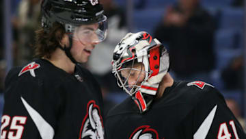 BUFFALO, NEW YORK - DECEMBER 13: Owen Power #25 and Craig Anderson #41 of the Buffalo Sabres meet after the game against the Los Angeles Kings at KeyBank Center on December 13, 2022 in Buffalo, New York. (Photo by Joshua Bessex/Getty Images)