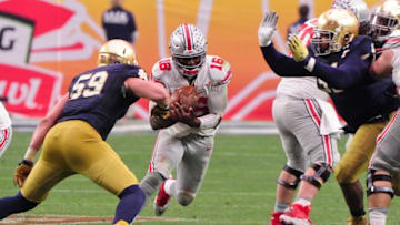 Jan 1, 2016; Glendale, AZ, USA; Ohio State Buckeyes quarterback J.T. Barrett (16) runs the ball as Notre Dame Fighting Irish linebacker Jarrett Grace (59) during the second half in the 2016 Fiesta Bowl at University of Phoenix Stadium. Mandatory Credit: Matt Kartozian-USA TODAY Sports