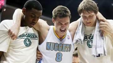 Apr 4, 2013; Denver, CO, USA; Denver Nuggets forward Danilo Gallinari (8) is helped off the court by center Timofey Mozgov (right) and forward Quincy Miller (left) after injuring his knee during the first half against the Dallas Mavericks at the Pepsi Center. Mandatory Credit: Chris Humphreys-USA TODAY Sports