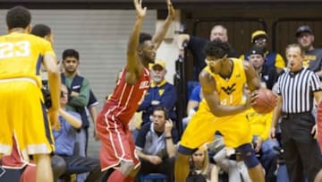 Feb 20, 2016; Morgantown, WV, USA; West Virginia Mountaineers forward Devin Williams (41) dribbles the ball as Oklahoma Sooners forward Khadeem Lattin (12) defends during the first half at the WVU Coliseum. Mandatory Credit: Ben Queen-USA TODAY Sports