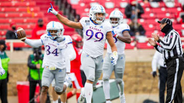 LUBBOCK, TEXAS - DECEMBER 05: Defensive lineman Malcom Lee #99 of the Kansas Jayhawks celebrates after a fumble recovery by Nate Betts #34 during the second half of the college football game against the Texas Tech Red Raiders at Jones AT&T Stadium on December 05, 2020 in Lubbock, Texas. (Photo by John E. Moore III/Getty Images)
