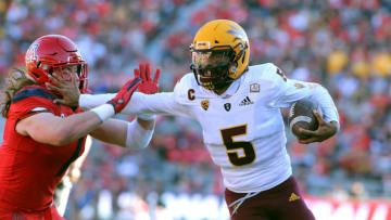 TUCSON, AZ - NOVEMBER 24: Quarterback Manny Wilkins #5 of the Arizona State Sun Devils stiff-arms linebacker Colin Schooler #7 of the Arizona Wildcats on a run during the first half of the college Football game at Arizona Stadium on November 24, 2018 in Tucson, Arizona. (Photo by Ralph Freso/Getty Images)