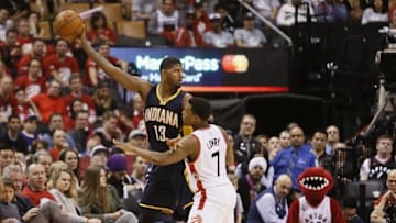 Apr 16, 2016; Toronto, Ontario, CAN; Indiana Pacers forward Paul George (13) keeps the ball away from Toronto Raptors guard Kyle Lowry (7) in game one of the first round of the 2016 NBA Playoffs at Air Canada Centre. Indiana defeated Toronto 100-90. Mandatory Credit: John E. Sokolowski-USA TODAY Sports