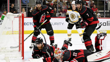 RALEIGH, NORTH CAROLINA - MAY 02: Ian Cole #28 and Antti Raanta #32 of the Carolina Hurricanes lay out to block a shot by the Boston Bruins during the third period of Game One of the First Round of the 2022 Stanley Cup Playoffs at PNC Arena on May 02, 2022 in Raleigh, North Carolina. The Hurricanes won 5-1. (Photo by Grant Halverson/Getty Images)