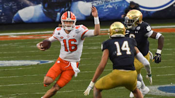 Dec 19, 2020; Charlotte, NC, USA; Clemson quarterback Trevor Lawrence (16) runs near Notre Dame safety Kyle Hamilton (14) during the second quarter of the ACC Championship game at Bank of America Stadium. Mandatory Credit: Ken Ruinard-USA TODAY Sports
