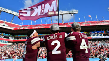 TAMPA, FLORIDA - JANUARY 02: Nathaniel Watson #14, Will Rogers III #2, and Jett Johnson #44 of the Mississippi State Bulldogs wave a Mike flag in memory of Mike Leach after defeating the Illinois Fighting Illini 19-10 in the ReliaQuest Bowl at Raymond James Stadium on January 02, 2023 in Tampa, Florida. (Photo by Julio Aguilar/Getty Images)