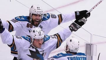 May 3, 2013; Vancouver, British Columbia, CAN; San Jose Sharks forward Raffi Torres (13) is congratulated by San Jose Sharks defenseman Brent Burns (88) and San Jose Sharks center Joe Thornton (19) after scoring the winning goal against Vancouver Canucks goaltender Roberto Luongo (1) (not pictured) during overtime of game two of the first round of the 2013 Stanley Cup playoffs at Rogers Arena. The San Jose Sharks won 3-2 in overtime. Mandatory Credit: Anne-Marie Sorvin-USA TODAY Sports
