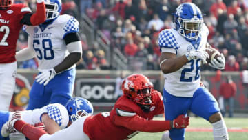 Nov 26, 2016; Louisville, KY, USA; Kentucky Wildcats running back Benny Snell Jr. (26) tries to break the tackle of Louisville Cardinals defensive tackle Kyle Shortridge (95) during the second quarter at Papa John
