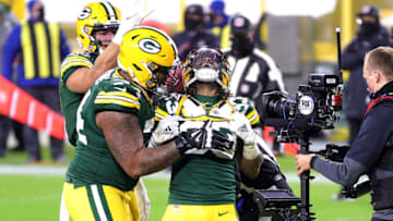 GREEN BAY, WISCONSIN - JANUARY 16: Aaron Jones #33 of the Green Bay Packers celebrates scoring a touchdown in the third quarter against the Los Angeles Rams during the NFC Divisional Playoff game at Lambeau Field on January 16, 2021 in Green Bay, Wisconsin. (Photo by Stacy Revere/Getty Images)