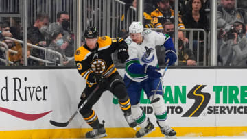 Nov 28, 2021; Boston, Massachusetts, USA; Boston Bruins center Charlie Coyle (13) and Vancouver Canucks defenseman Luke Schenn (2) battle for the puck during the second period at TD Garden. Mandatory Credit: Gregory Fisher-USA TODAY Sports