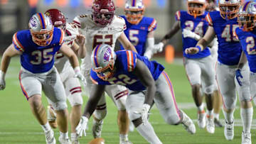 Bolles Bulldogs defensive lineman Garrison Butler picks up a fumble during game against Episcopal Eagles. Florida Times-Union.